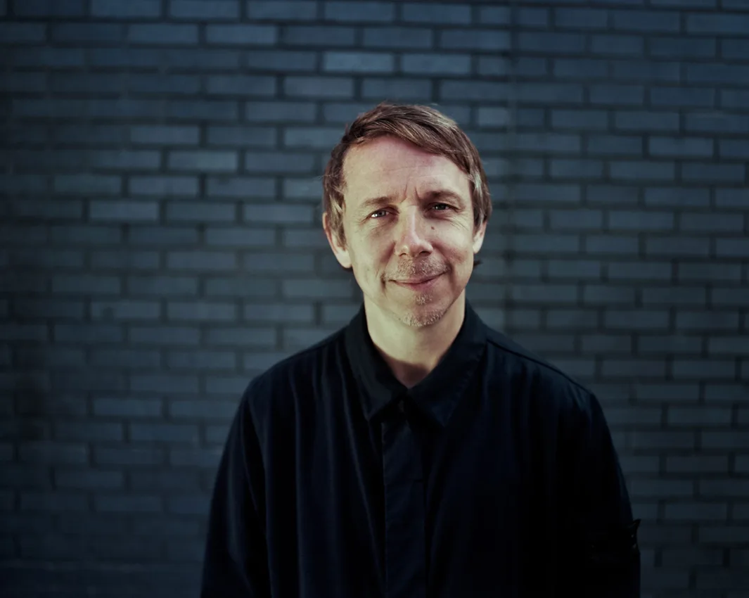 Gilles Peterson portrait in front of a brick wall