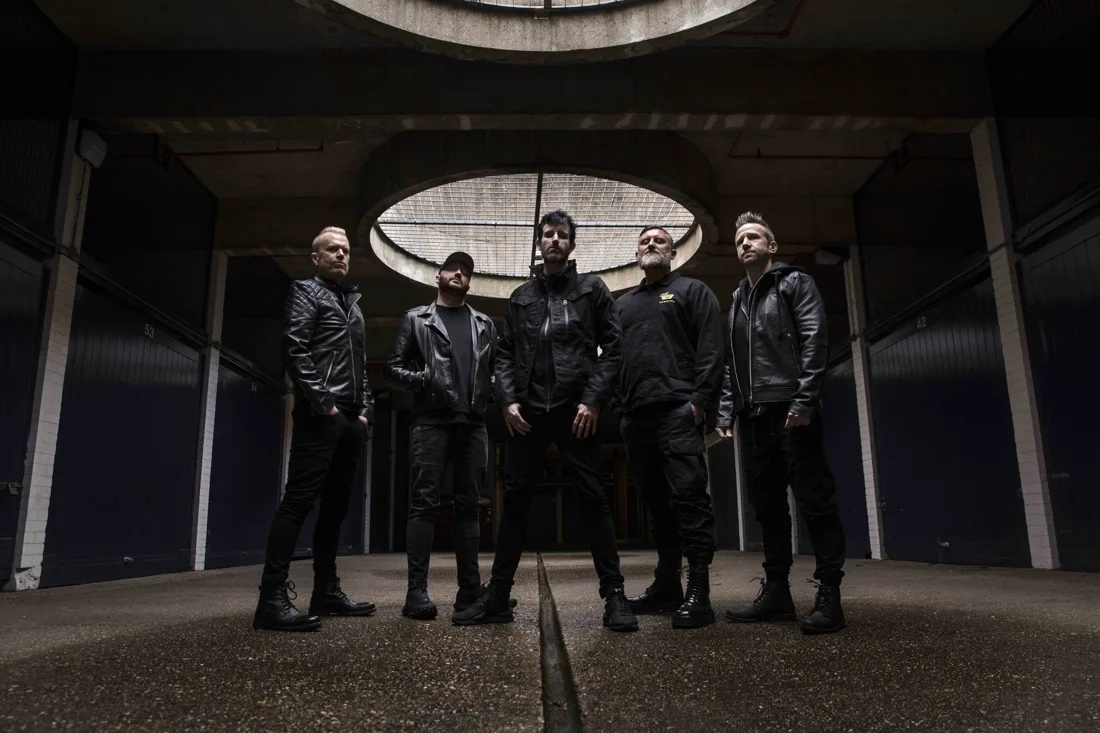 Five members of Pendulum standing beneath circular skylights