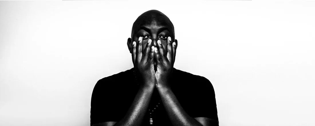 THEMBA promotional portrait with his hands raised towards his face