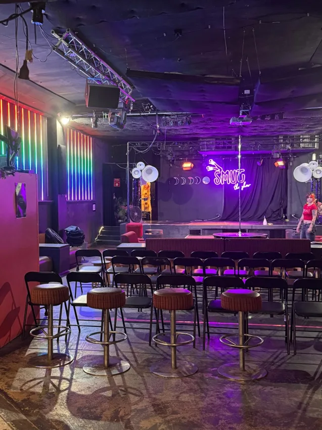 24 Moons show room with stage, neon sign, chairs and stools