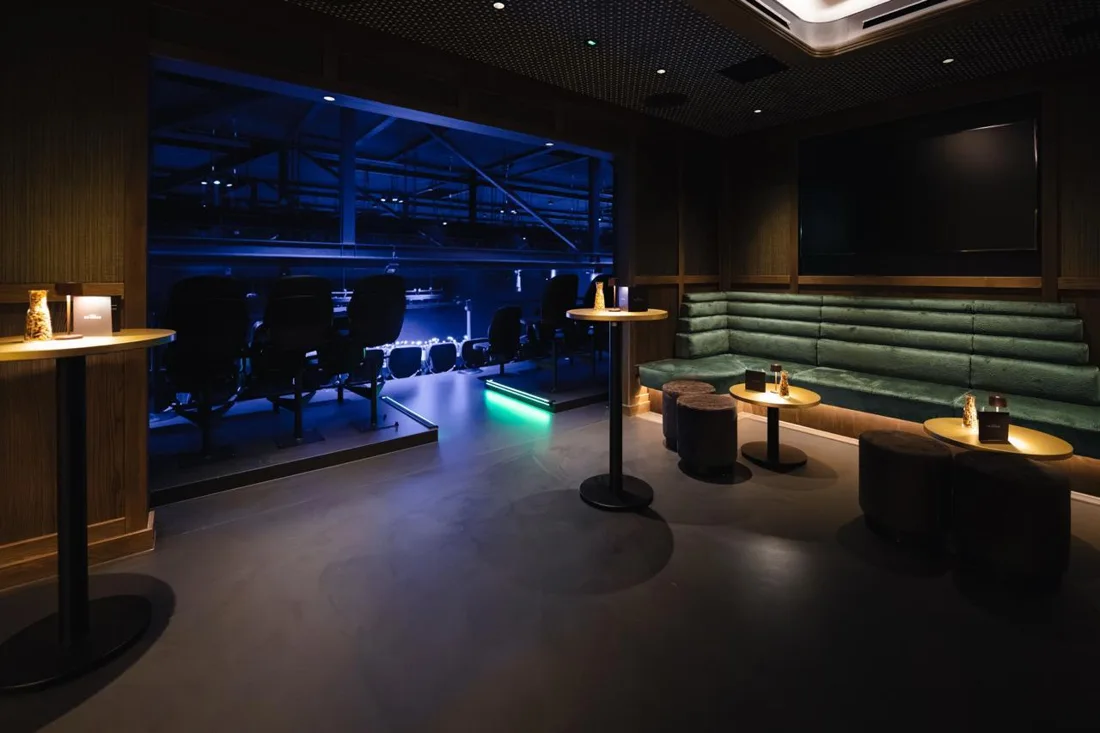 Afas Live sky lounge with green banquettes overlooking the blue-lit arena seating