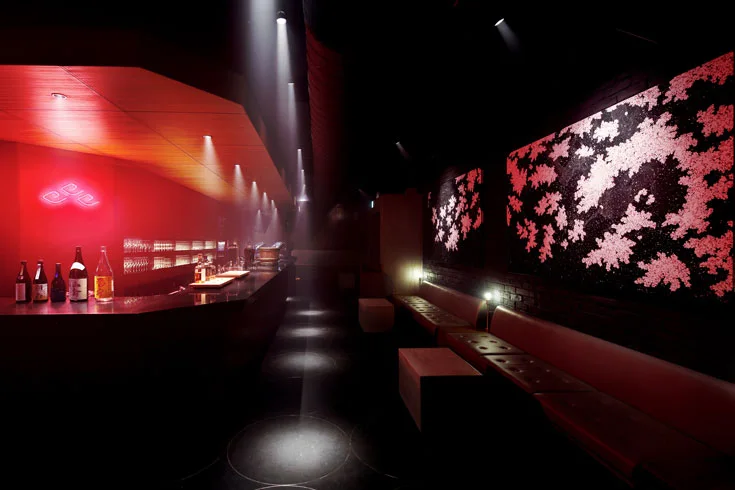 Azumaya red-lit lounge bar with cherry-blossom wall panels and banquettes