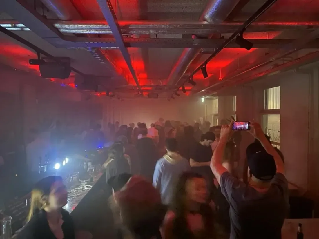 Borisov Amsterdam red-lit industrial room with exposed ducts, bar and dancers