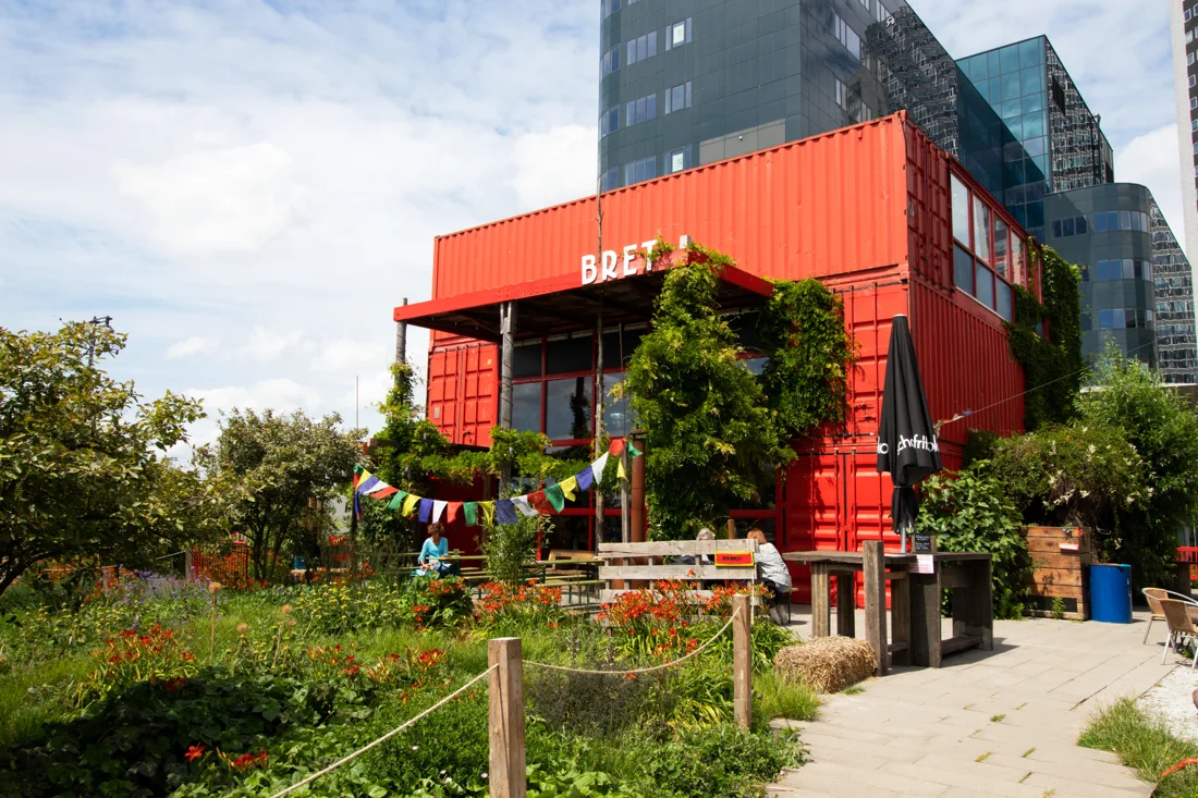 BRET red stacked-container building with its sign, garden and bunting