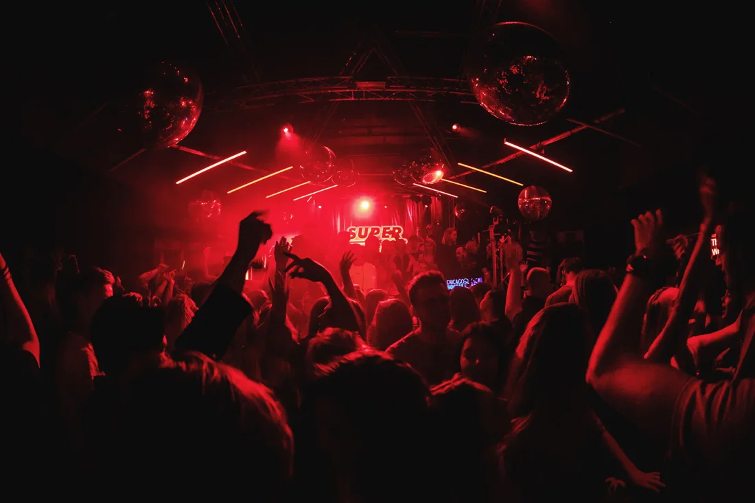 Chicago Social Club dancefloor in red light under mirror balls and truss