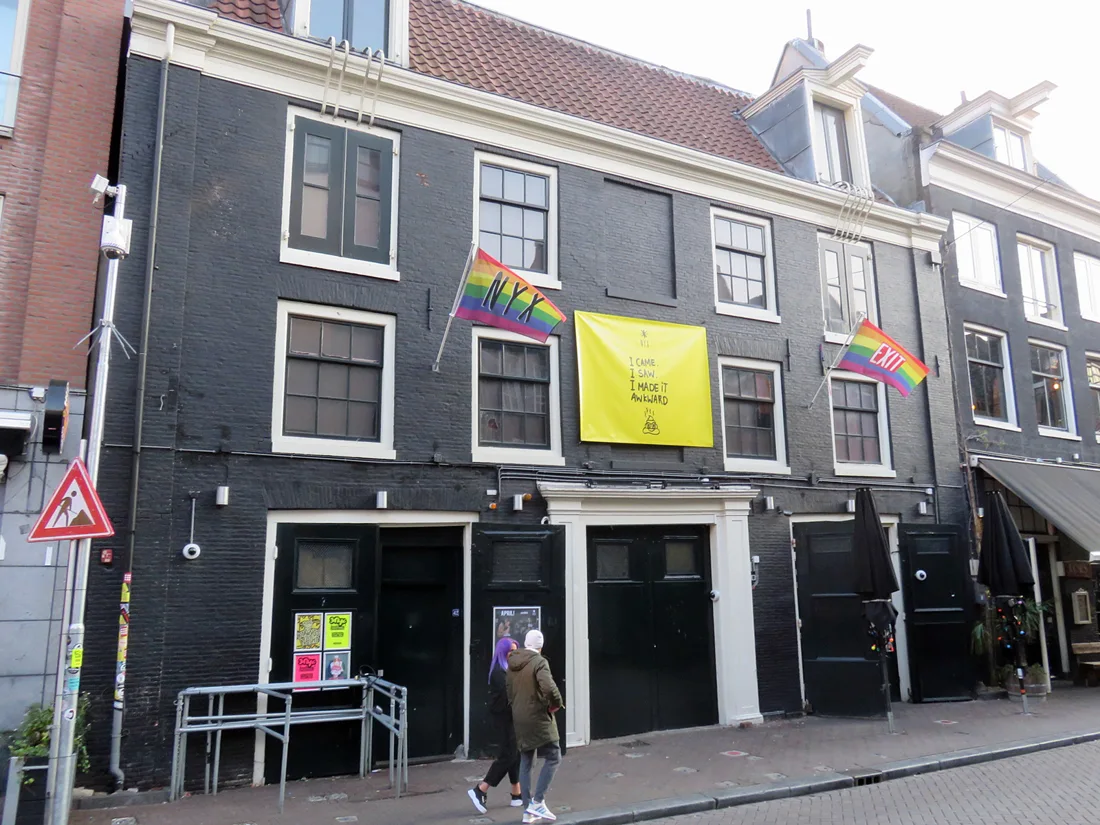 Club NYX black-painted canal house facade with NYX rainbow flag
