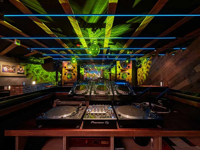 DJ BAR Bridge Shinjuku DJ booth with turntables under projection-lit ceiling