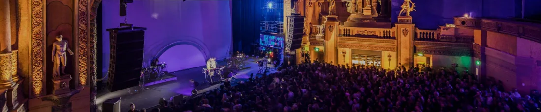 A live performance and standing audience beneath Forum Melbourne's ornate theatre arches