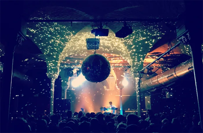Gretchen vaulted brick hall with mirror ball, DJ on stage, crowd