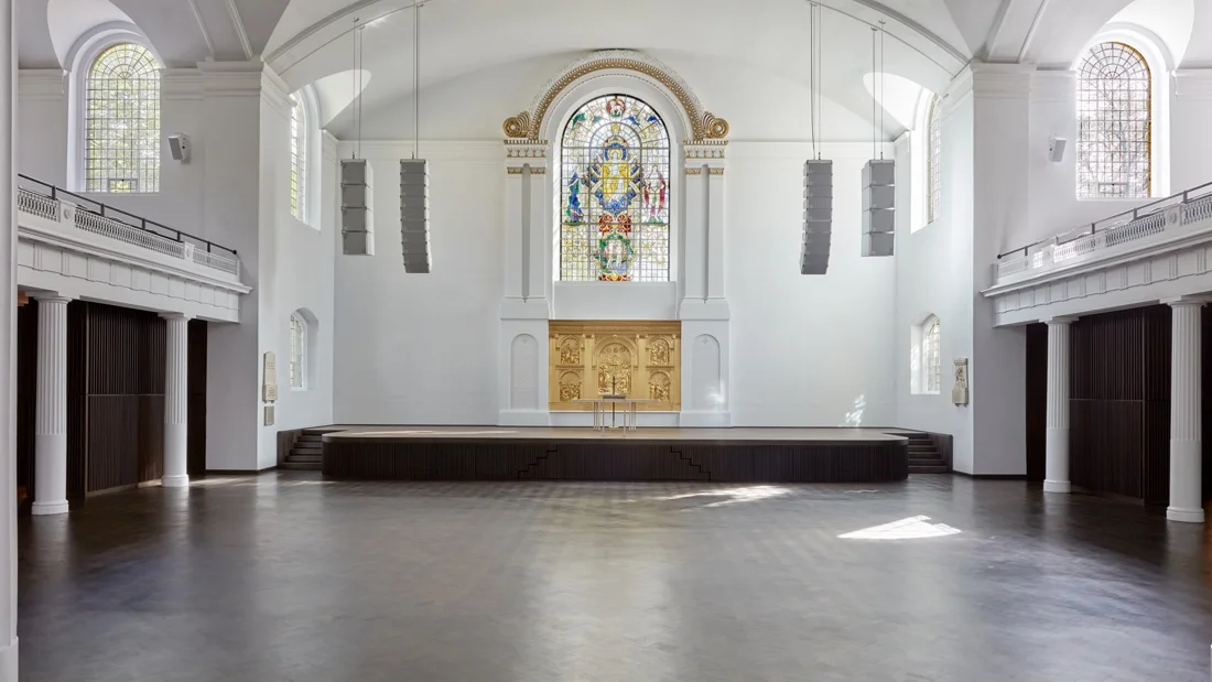 Hackney Church empty nave with stage, stained glass and galleries