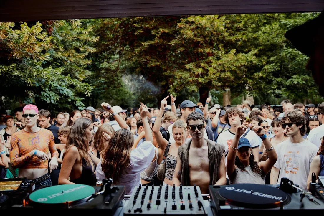 Gateway Festival crowd facing the DJ decks among the trees at Heide Sculpture Park
