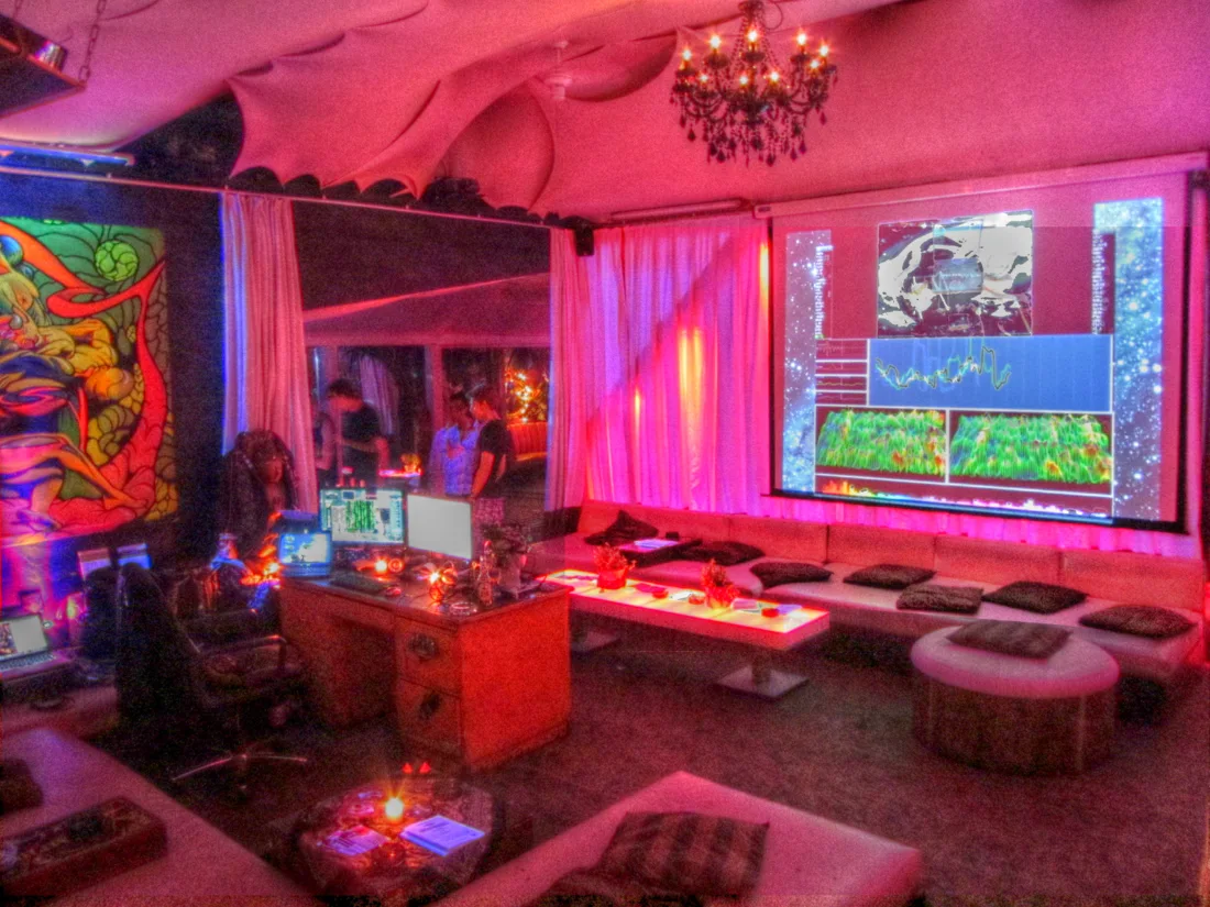 KitKatClub lounge in pink light with chandelier, sofas and art screens