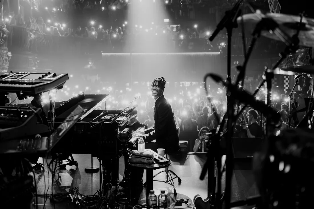 A musician at a piano on stage with a concert crowd and occupied balconies at KOKO