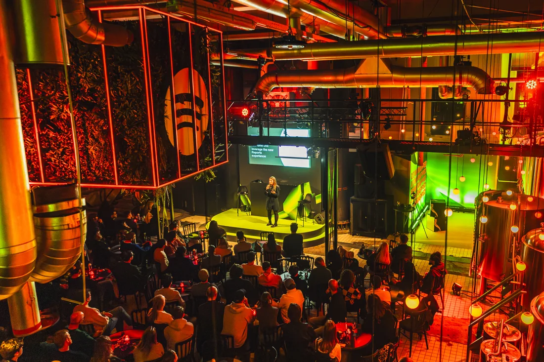 Levenslang Amsterdam boiler-house hall with pipes, neon and a seated audience