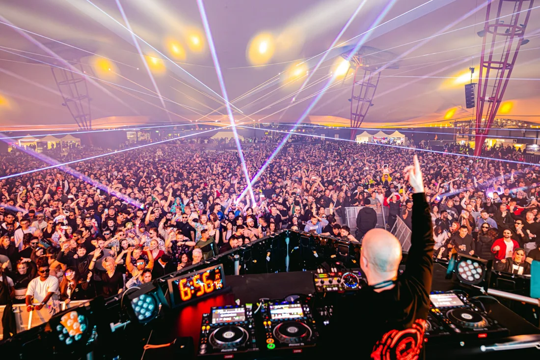 A DJ, packed audience and lasers beneath the pavilion roof at Melbourne Showgrounds