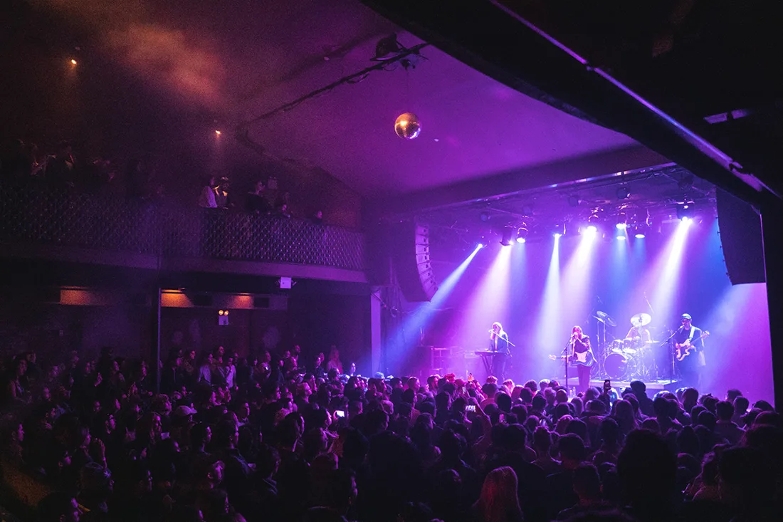 Music Hall of Williamsburg band on purple-lit stage, packed floor and balcony