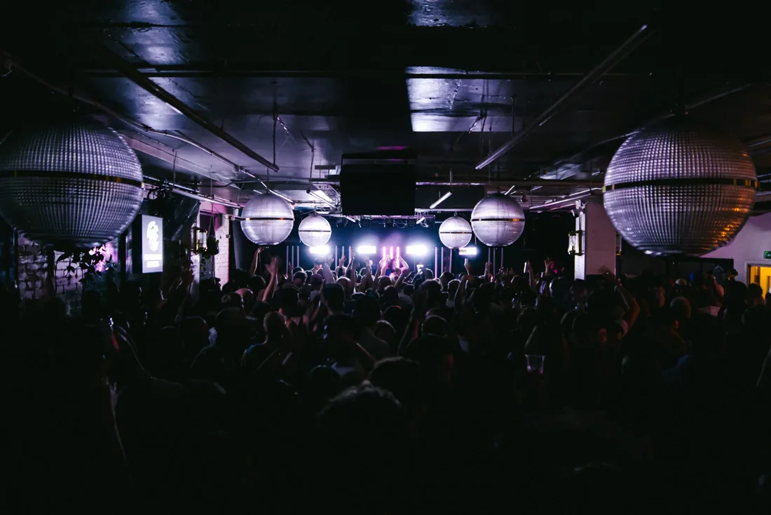 Night Tales Loft dark club floor with crowd, giant mirror globes and stage