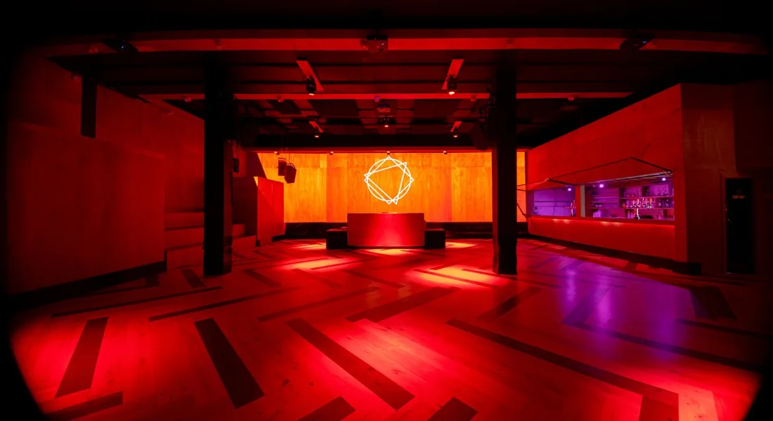 Number 90 empty Hideout room, red-lit wooden dancefloor, booth and bar