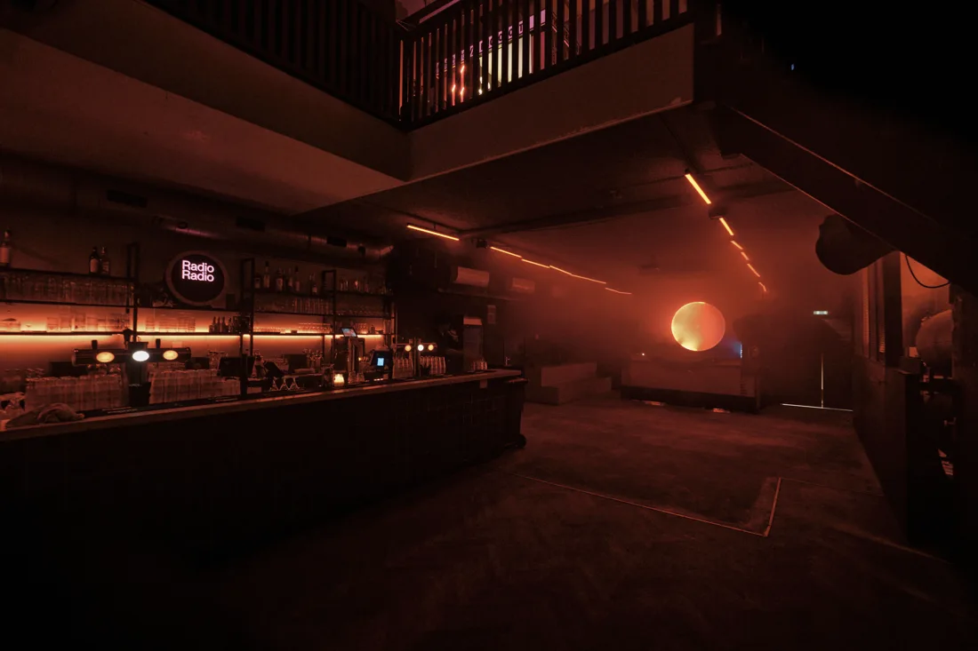 Radio Radio club with back-lit bar, Radio Radio sign and dancefloor