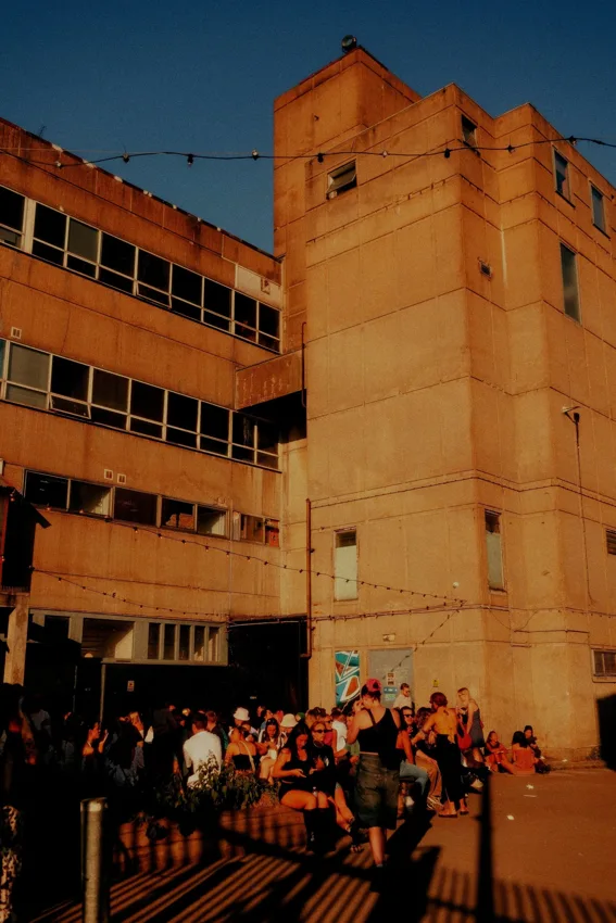 The Cause concrete warehouse building and yard with crowd at sunset