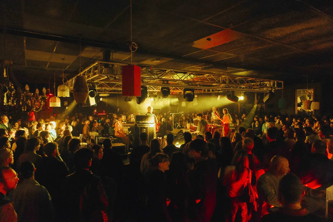 A crowd around the illuminated central stage at The Night Cat in Fitzroy