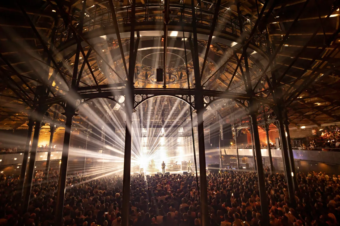 The Roundhouse main space during a gig, cast-iron columns and light beams