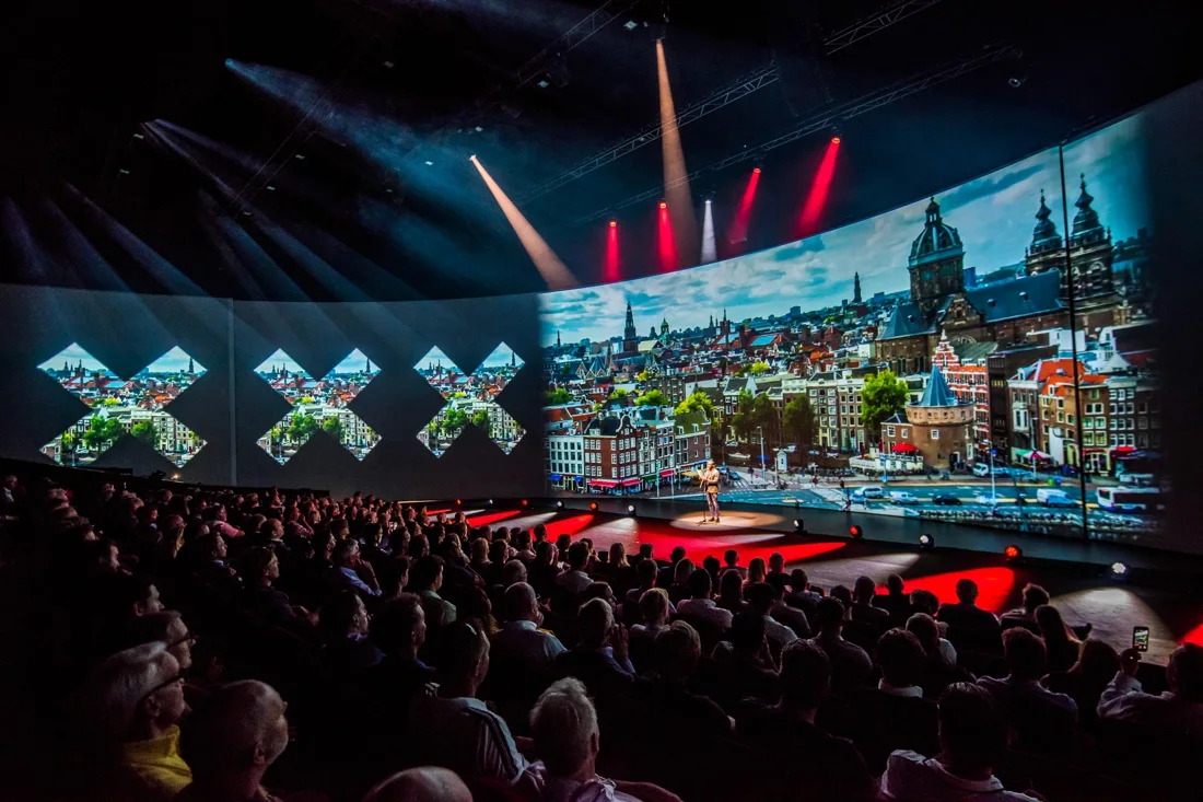 Theater Amsterdam auditorium with wraparound screen and full seats