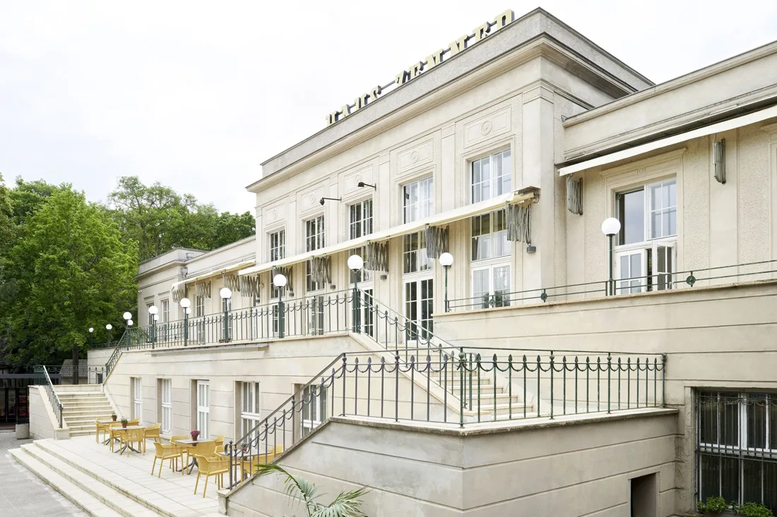 ZENNER cream historic building with terrace steps and tables
