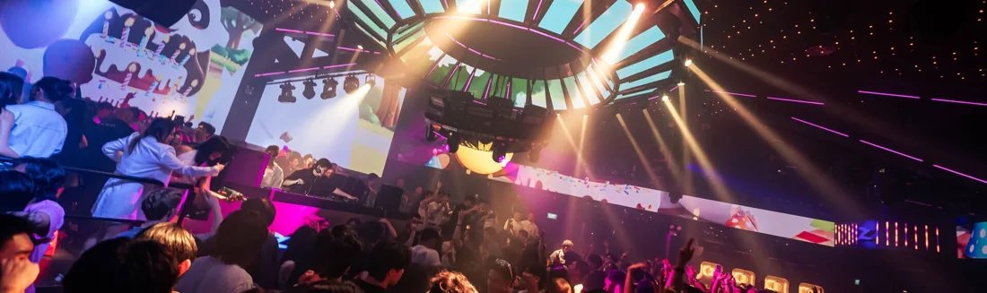DJ and crowd under coloured lights in Zouk Singapore’s main room